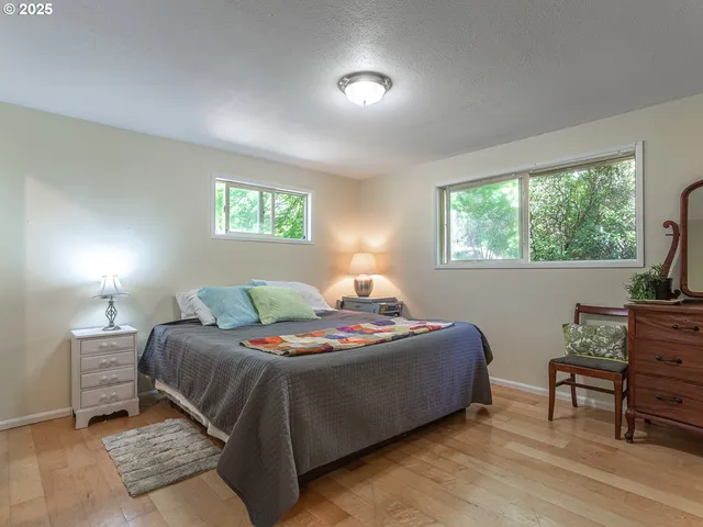 a bedroom with a bed and a table in it with window