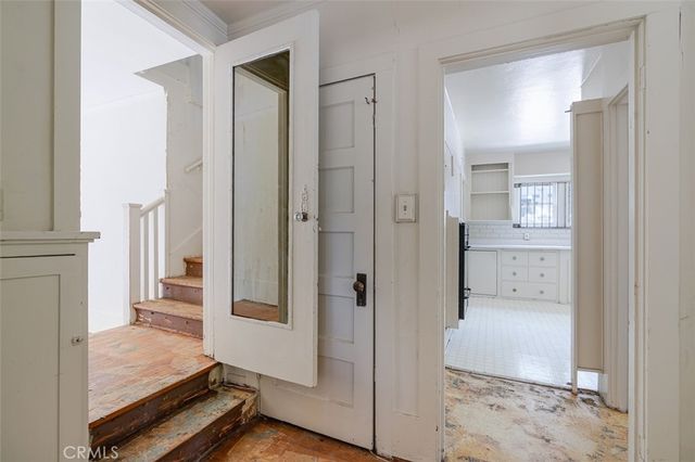 a view of a hallway with cabinet and stairs