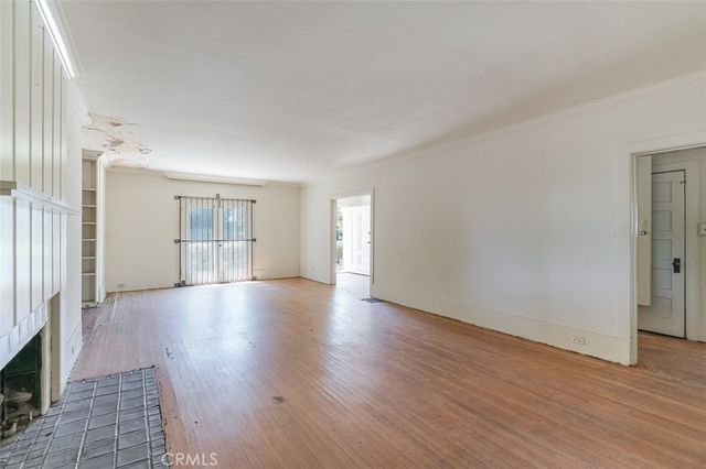 a view of empty room with wooden floor and fireplace