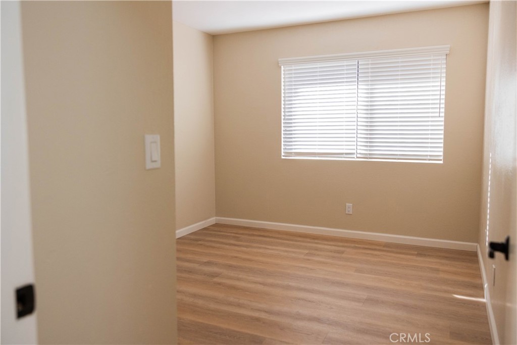 1219 Edwards Street, Unit 33 Redlands, CA 92374 - Photo 20 of 55 a view of an empty room with wooden floor and a window