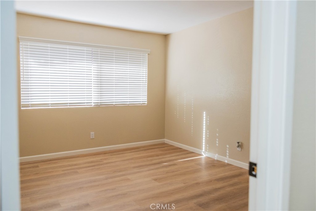 1219 Edwards Street, Unit 33 Redlands, CA 92374 - Photo 29 of 55 a view of an empty room with wooden floor and a window