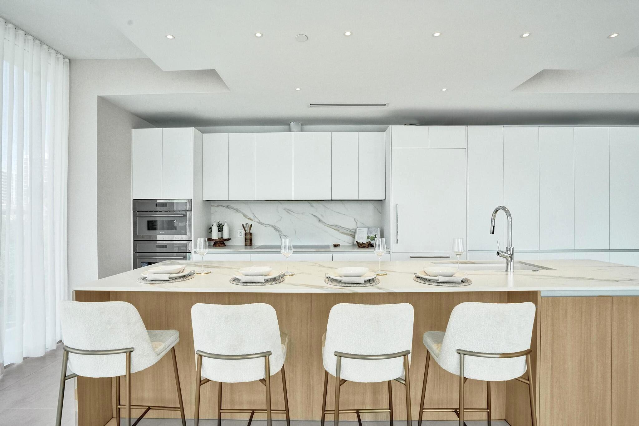 407 North Riverside Drive, Unit 203 Pompano Beach, FL 33062 - Photo 10 of 69 a kitchen with stainless steel appliances granite countertop a dining table chairs and white cabinets