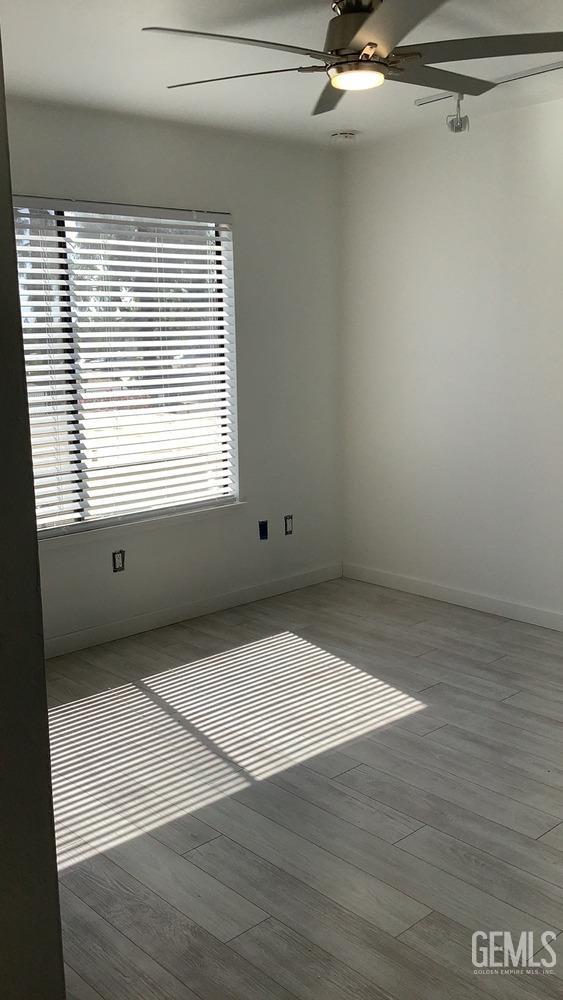 Undisclosed Address Bakersfield, CA 93309 - Photo 16 of 31 a view of an empty room with a window and wooden floor