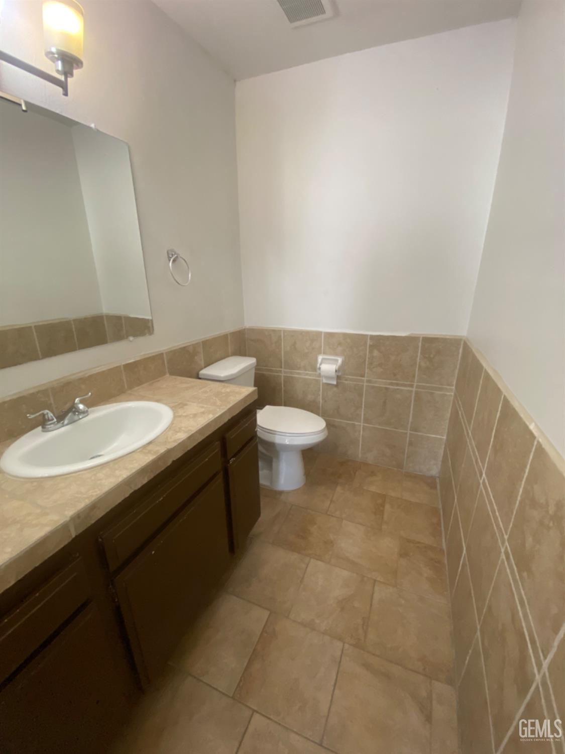 Undisclosed Address Bakersfield, CA 93309 - Photo 20 of 31 a bathroom with a granite countertop sink a toilet and a mirror