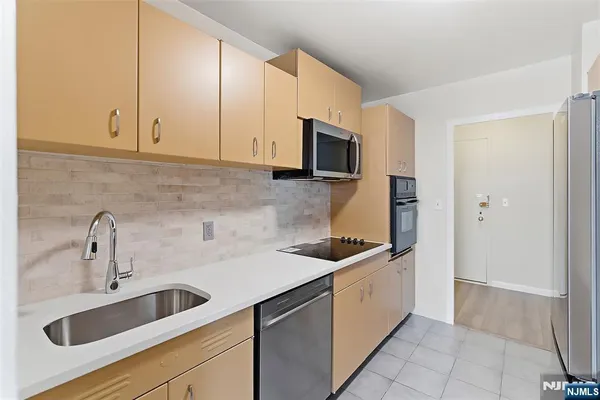 a kitchen with stainless steel appliances a refrigerator sink and cabinets