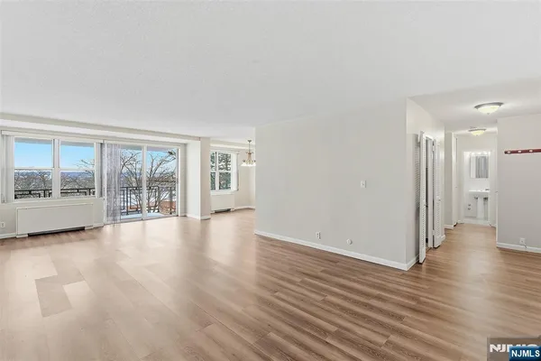 a view of an empty room with wooden floor