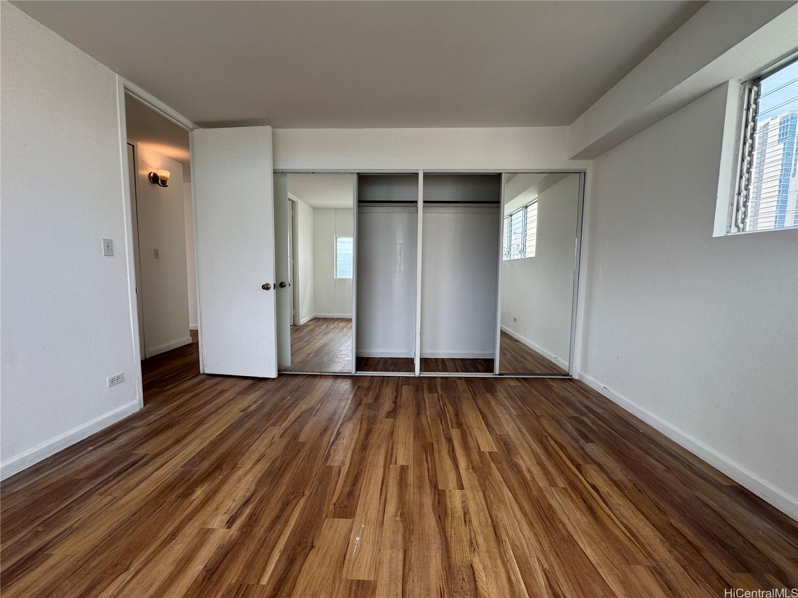 2085 Ala Wai Boulevard, Unit B94 Honolulu, HI 96815 - Photo 12 of 23 a view of an empty room with wooden floor and a window