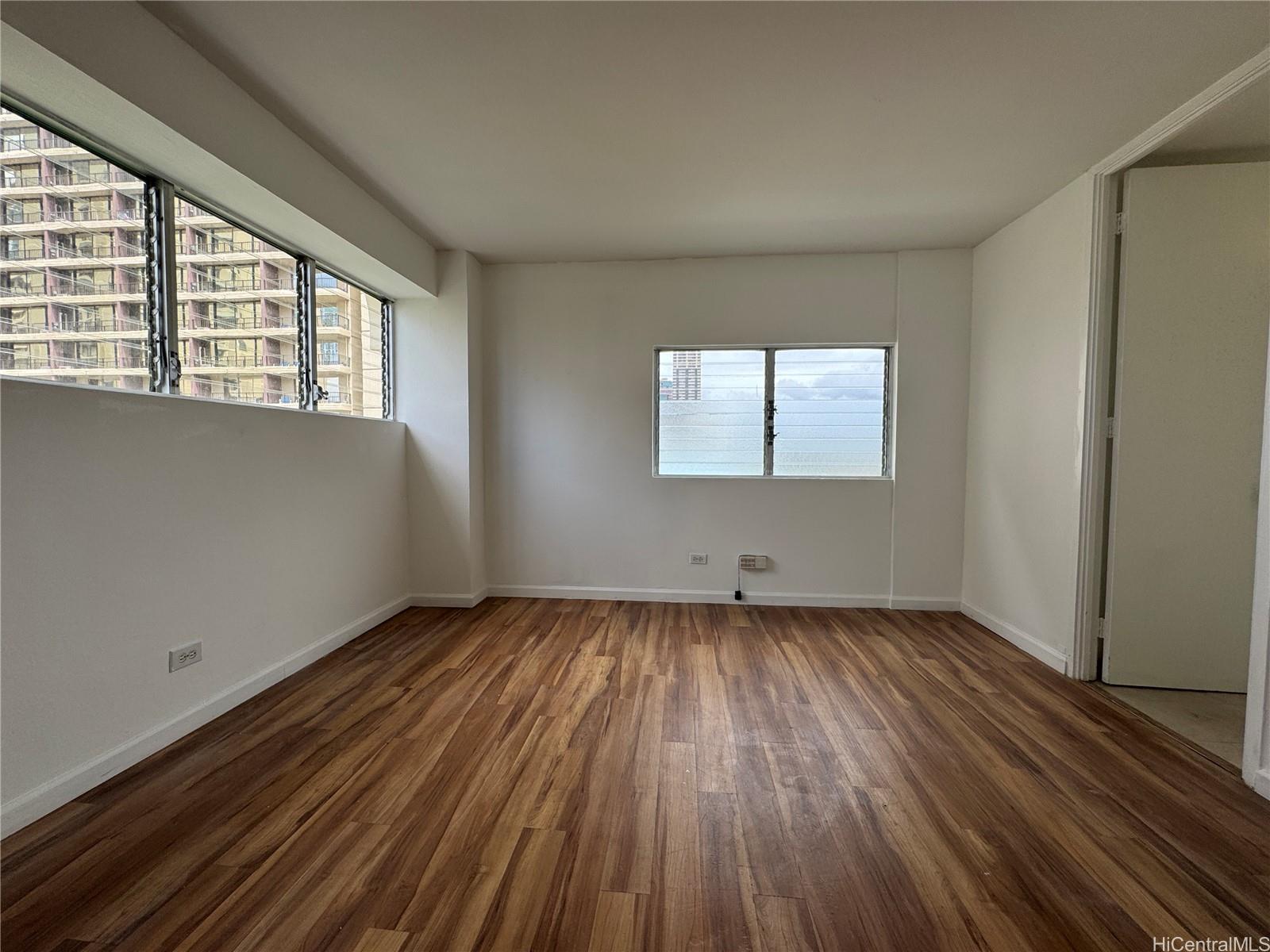 2085 Ala Wai Boulevard, Unit B94 Honolulu, HI 96815 - Photo 13 of 23 an empty room with wooden floor and windows