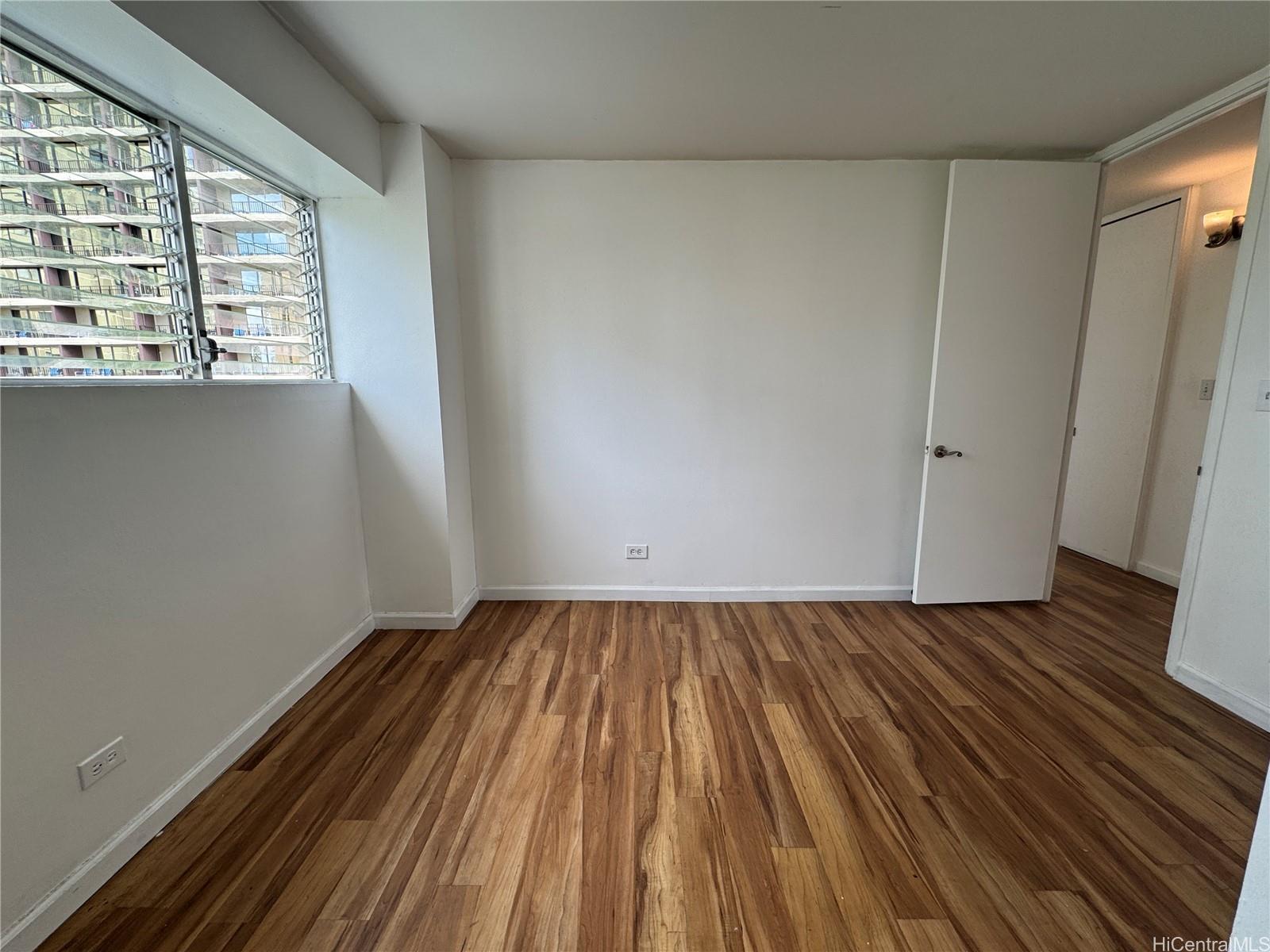 2085 Ala Wai Boulevard, Unit B94 Honolulu, HI 96815 - Photo 7 of 23 a view of an empty room with wooden floor and a window