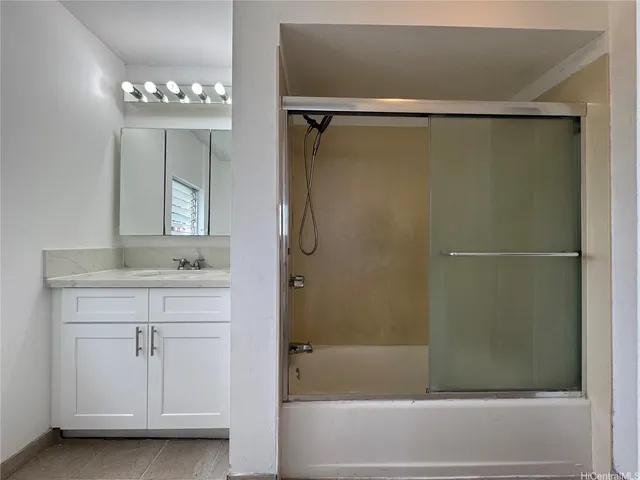 a bathroom with a shower a mirror and a sink