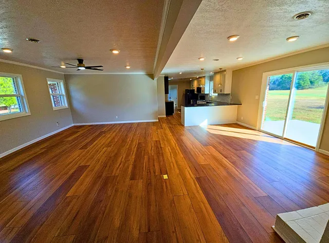 a view of empty room with wooden floor and windows