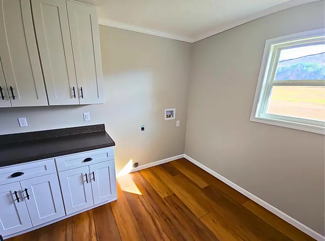 a view of a kitchen with wooden floor and cabinets