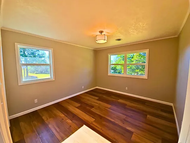 a view of a room with wooden floor