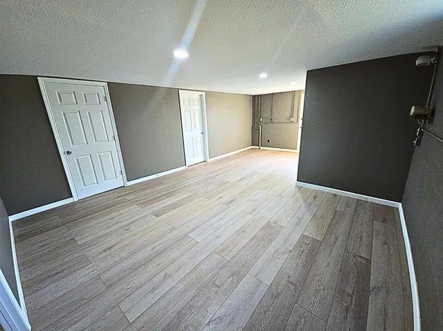 a view of an empty room with wooden floor