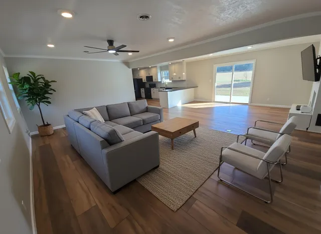 a view of an empty room with wooden floor and stairs