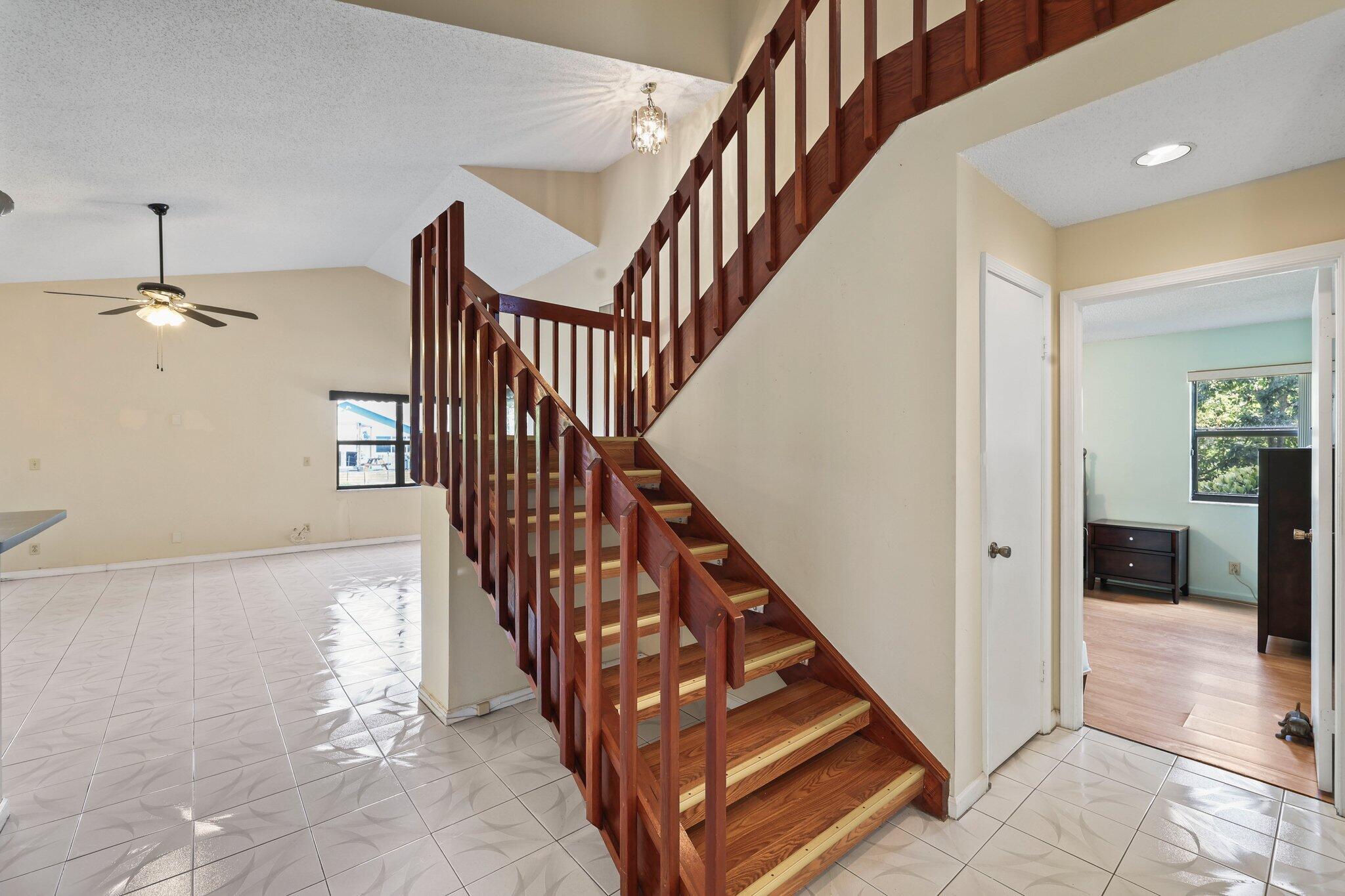 1235 Northwest 19th Terrace Delray Beach, FL 33445 - Photo 14 of 45 a view of staircase with lots of frames on wall and windows
