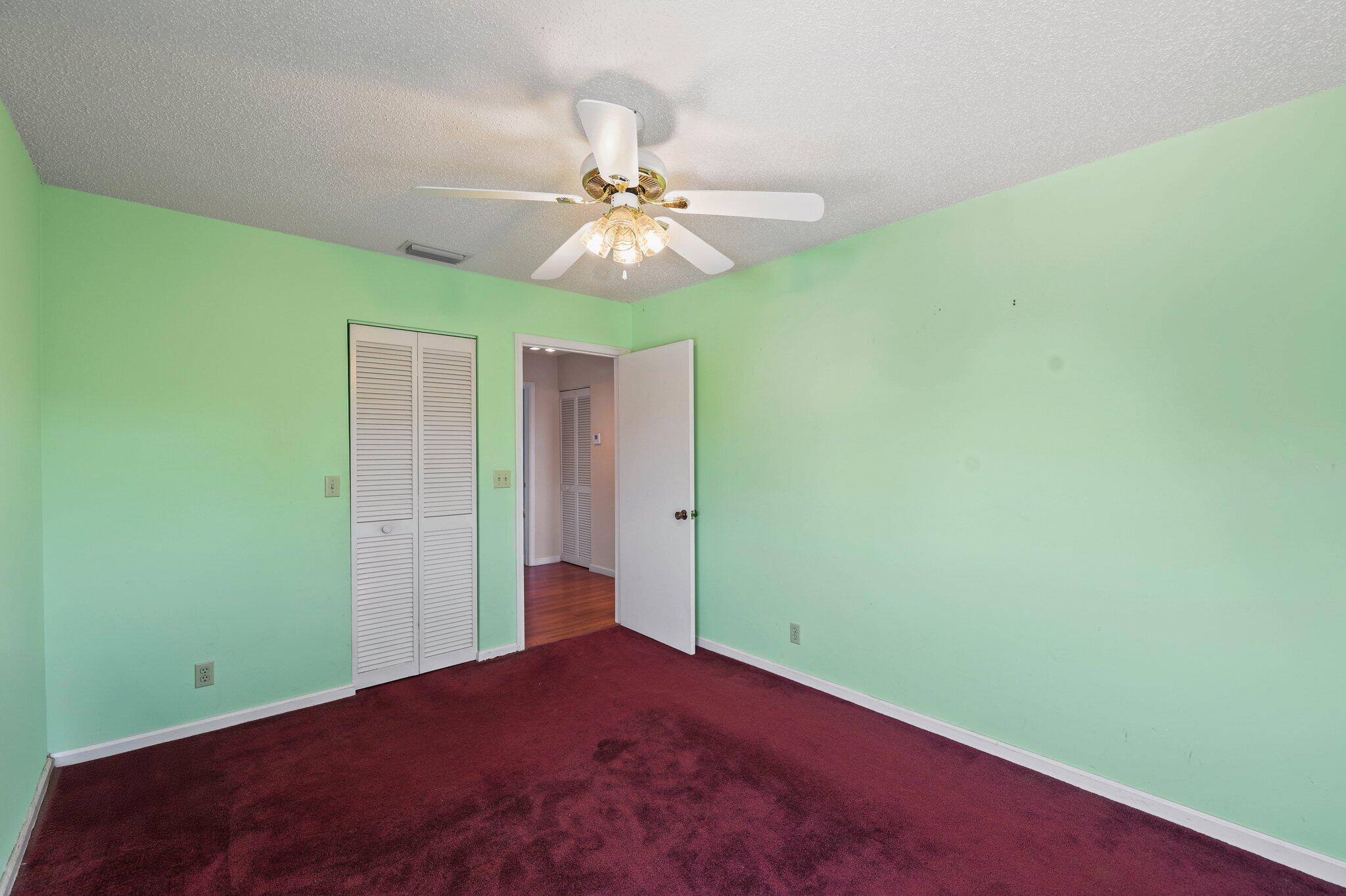1235 Northwest 19th Terrace Delray Beach, FL 33445 - Photo 21 of 45 an empty room with closet and a chandelier fan