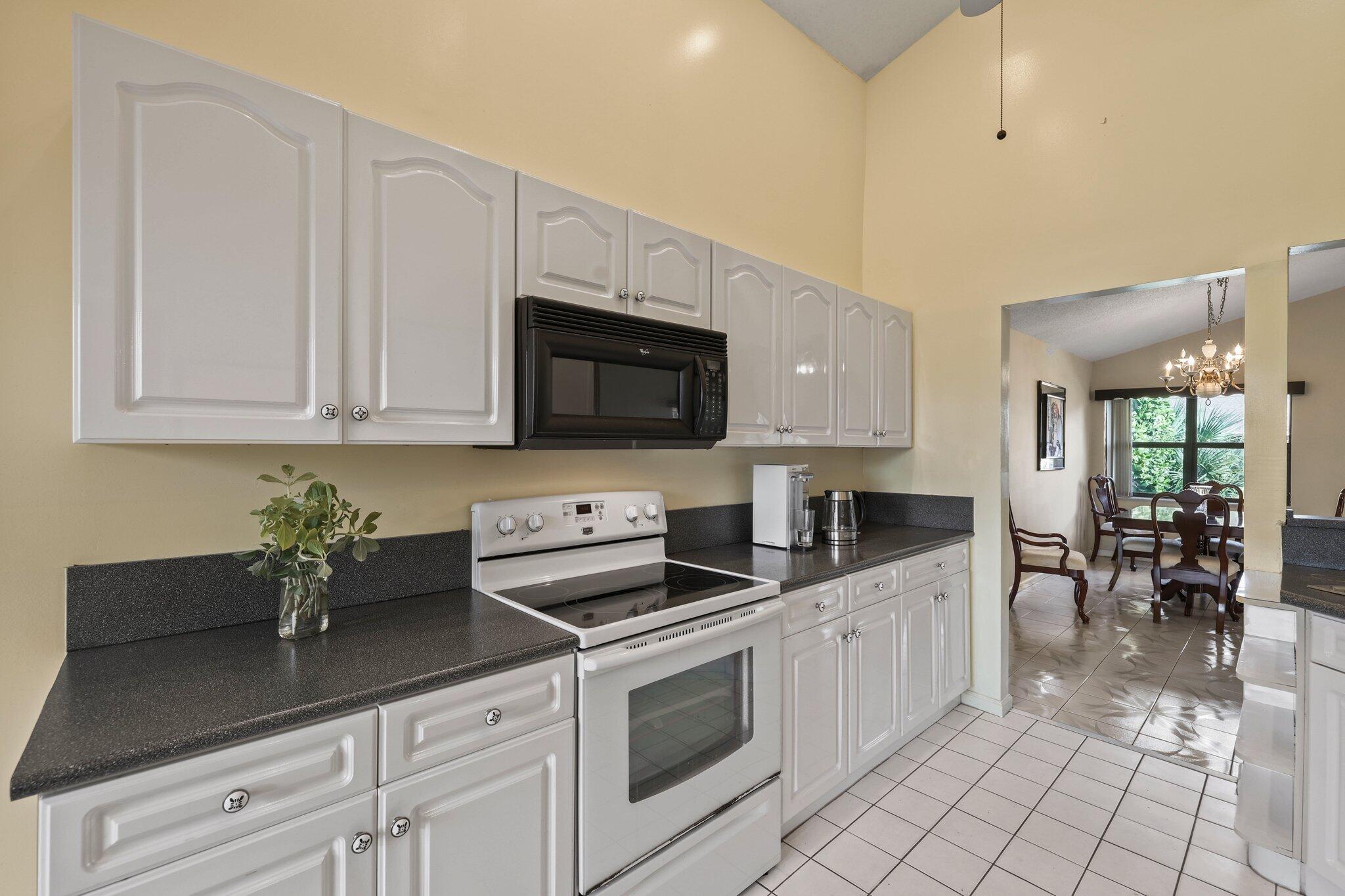 1235 Northwest 19th Terrace Delray Beach, FL 33445 - Photo 7 of 45 a kitchen with stainless steel appliances granite countertop a sink a stove and cabinets