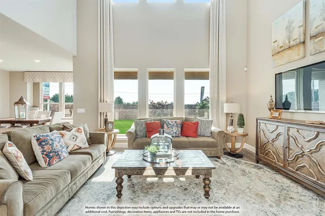 a living room with furniture large windows and wooden floor