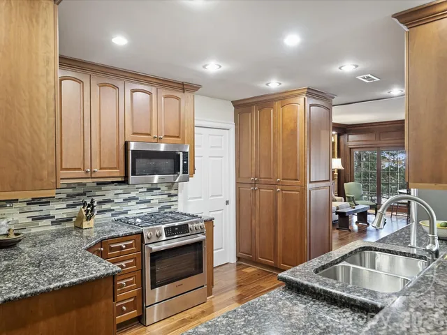 a kitchen with stainless steel appliances granite countertop a sink stove and refrigerator
