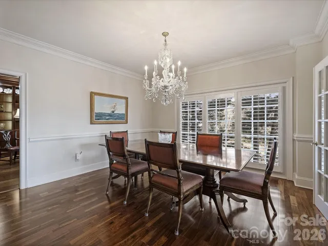a view of a dining room with furniture a chandelier and wooden floor