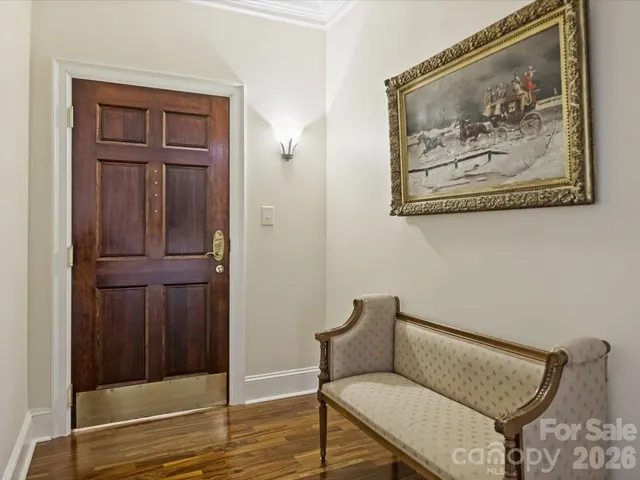 a view of a hallway with wooden floor and cabinet