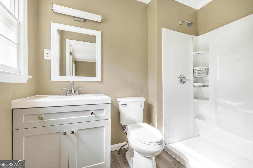 208 South 6th Street Vienna, GA 31092 - Photo 17 of 29 a bathroom with a sink toilet vanity and shower