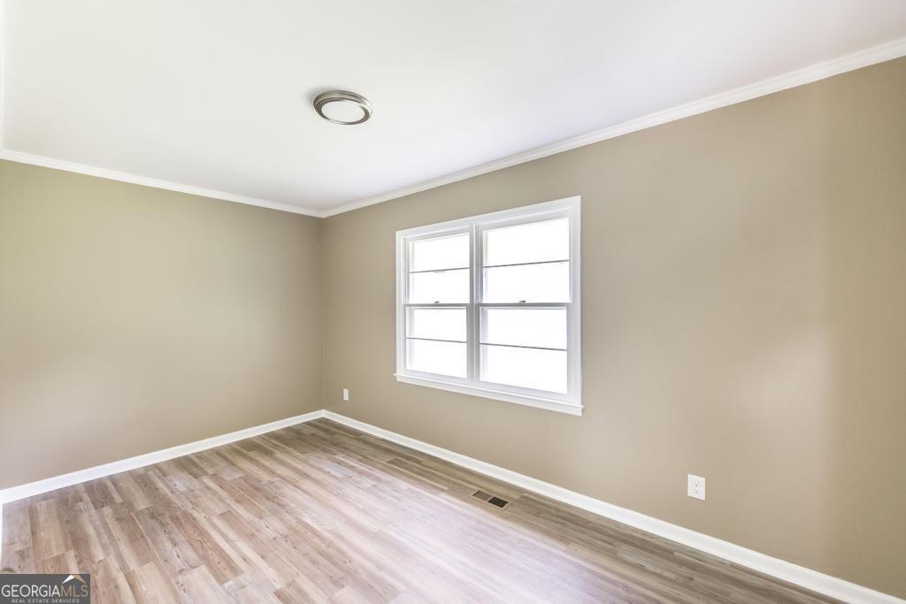 208 South 6th Street Vienna, GA 31092 - Photo 23 of 29 an empty room with wooden floor and windows