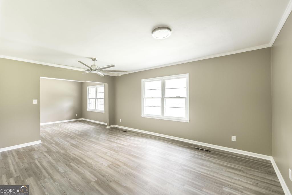 208 South 6th Street Vienna, GA 31092 - Photo 5 of 29 an empty room with wooden floor and windows