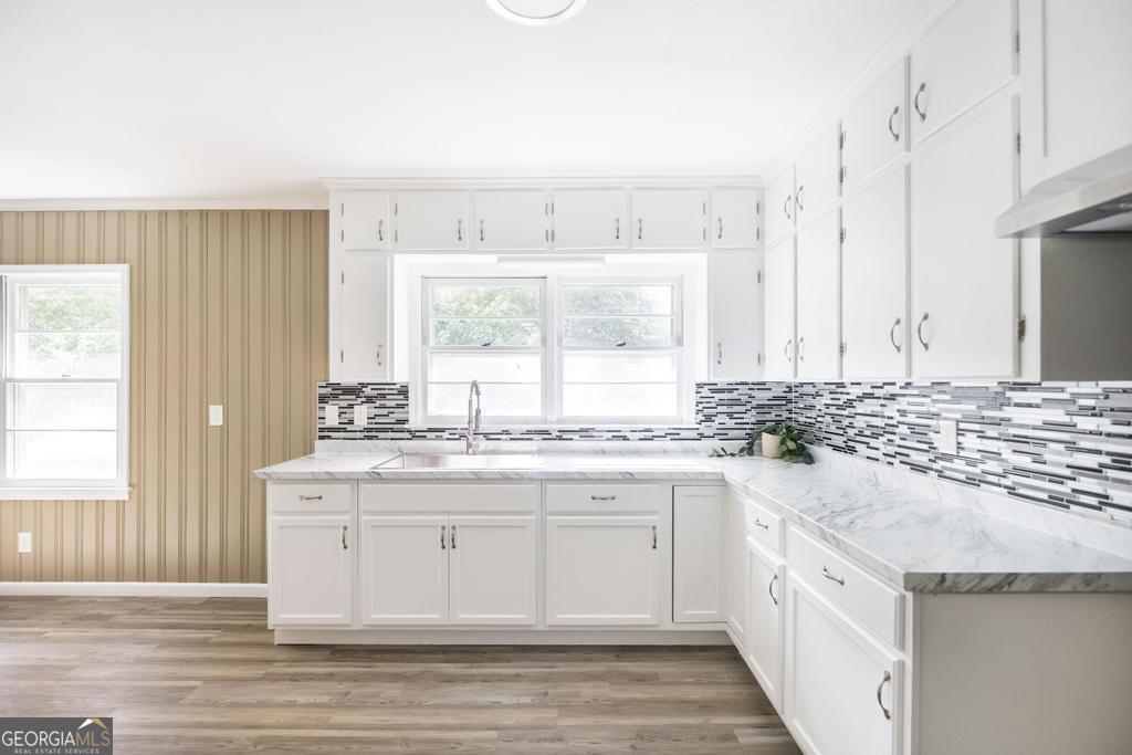 208 South 6th Street Vienna, GA 31092 - Photo 7 of 29 a kitchen with stainless steel appliances granite countertop a stove a sink and white cabinets with wooden floor