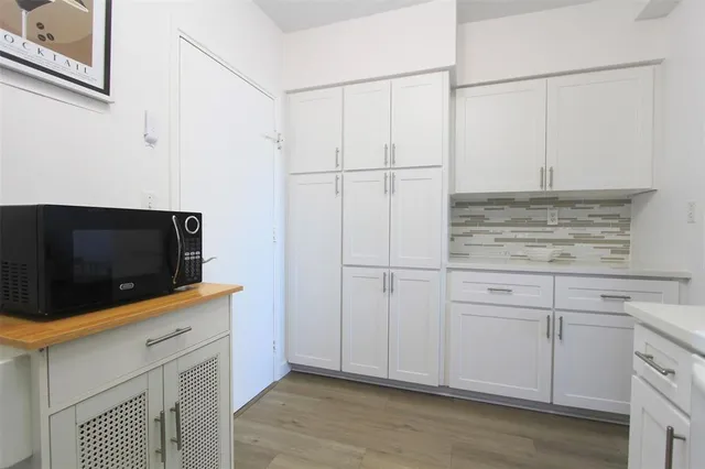 a kitchen with white cabinets and white appliances