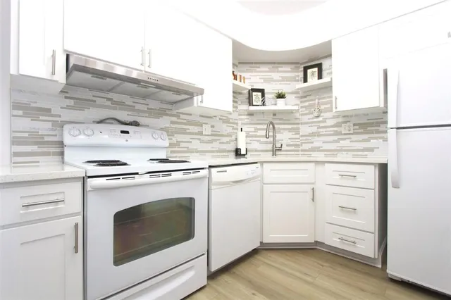 a kitchen with cabinets appliances and wooden floor