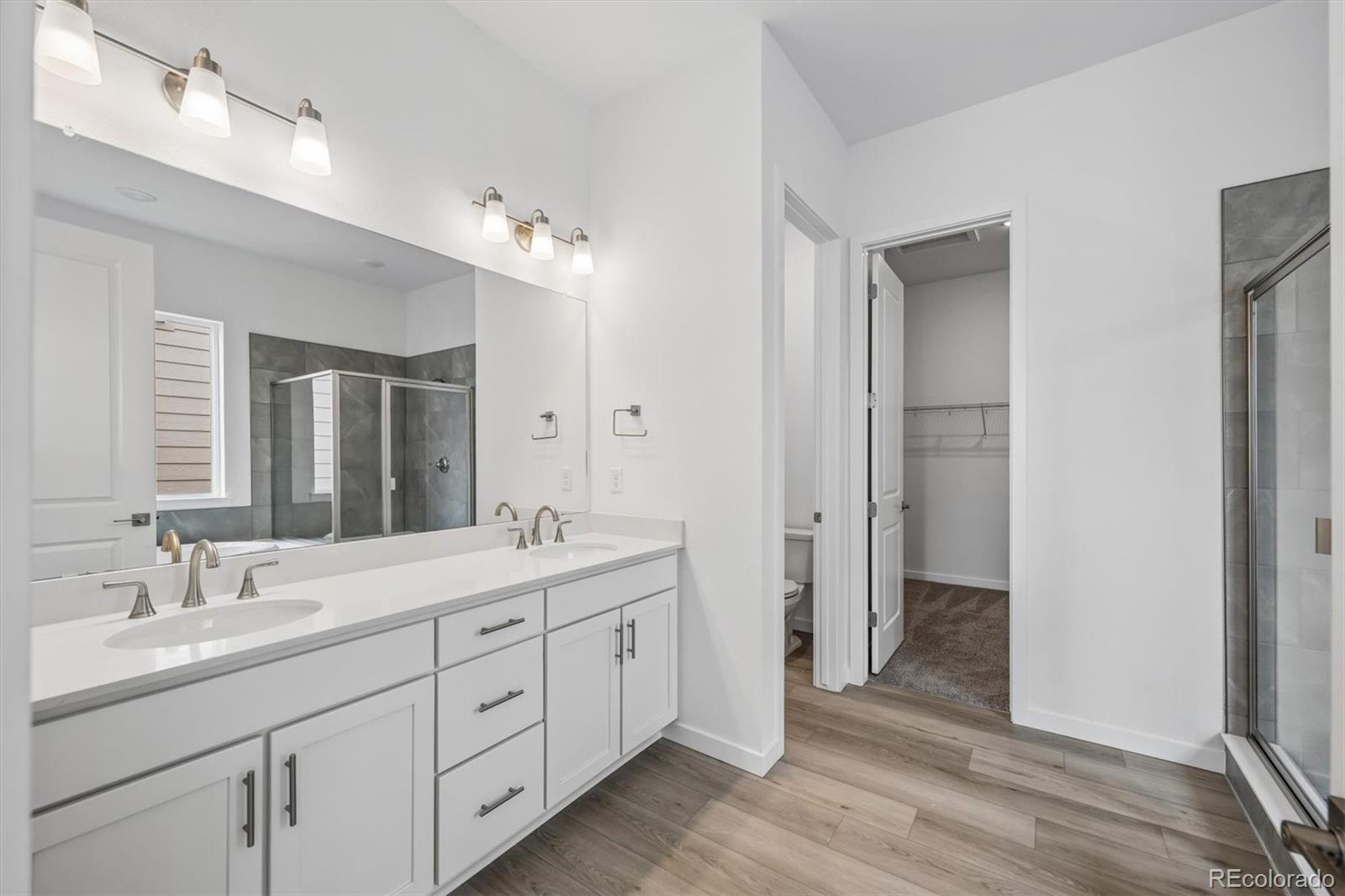 2516 West Bitterroot Place Highlands Ranch, CO 80129 - Photo 15 of 24 a spacious bathroom with a double vanity sink a large mirror a shower and a bathtub