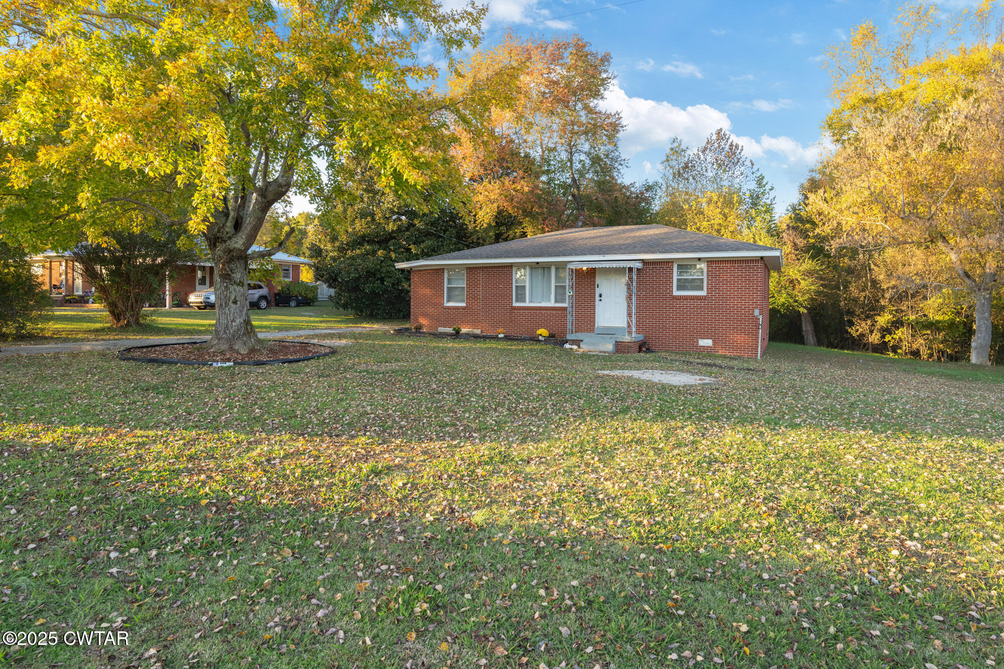 a view of a house with a big yard and large trees