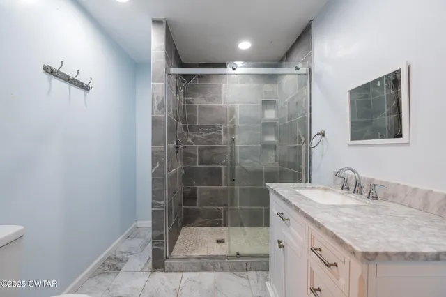 a bathroom with a shower sink and mirror