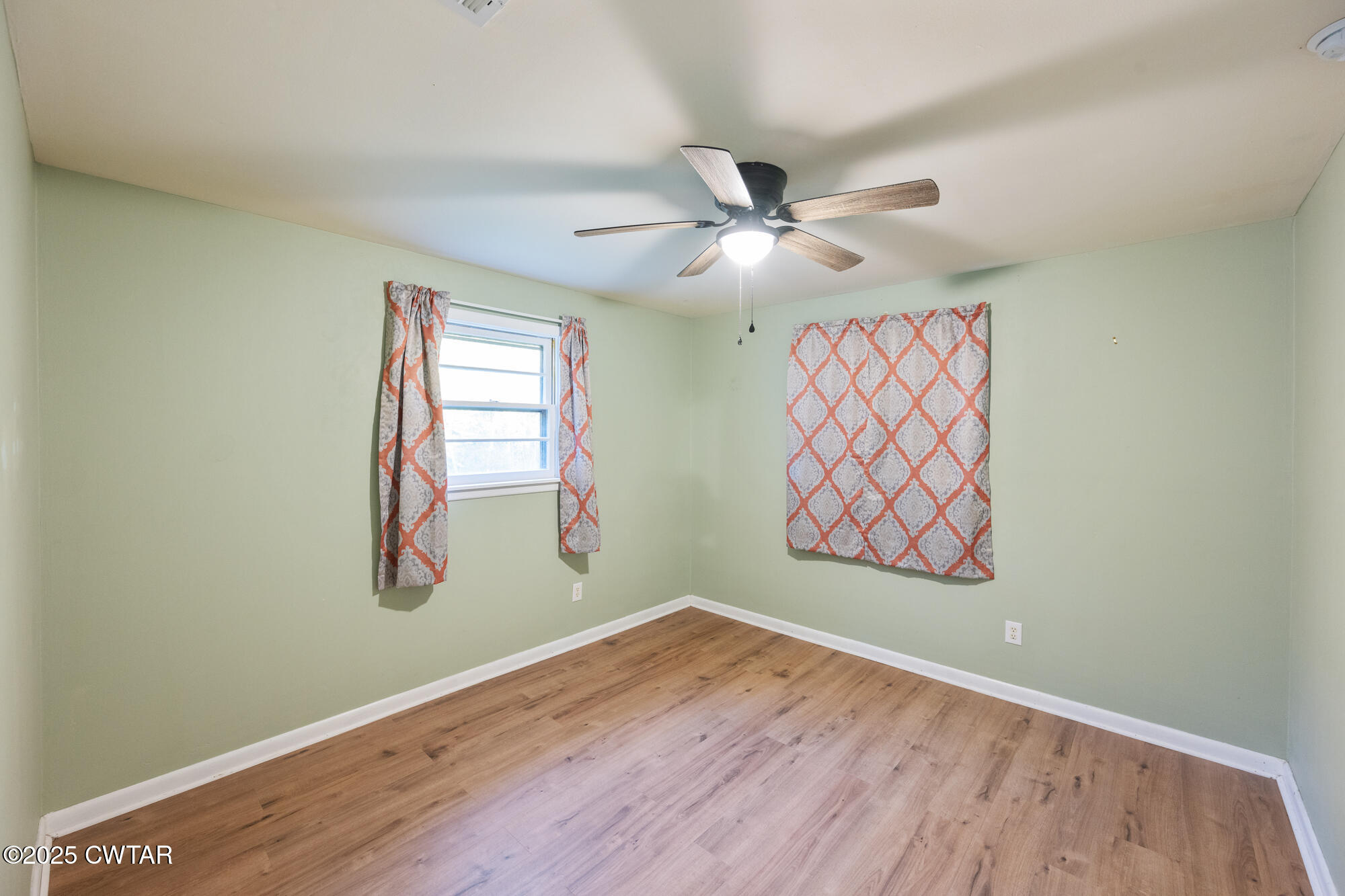 110 Highway 220 Cedar Grove, TN 38321 - Photo 7 of 12 an empty room with wooden floor fan and windows