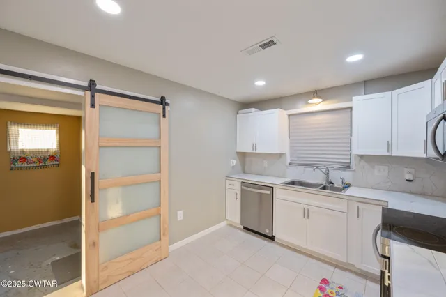 a kitchen with a sink stainless steel appliances and cabinets