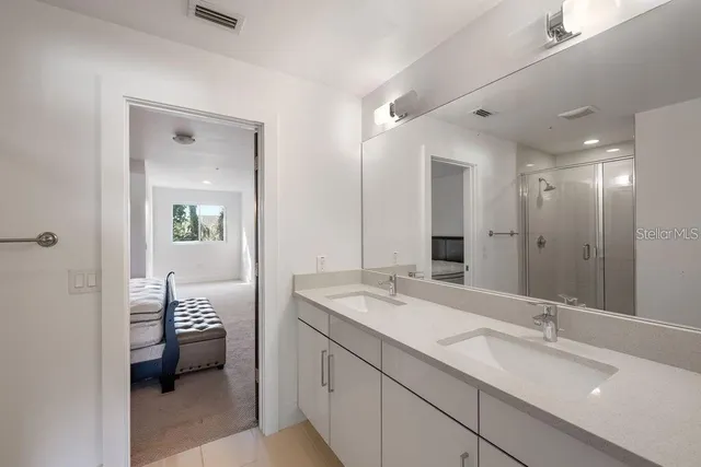 a bathroom with a sink double vanity and a shower