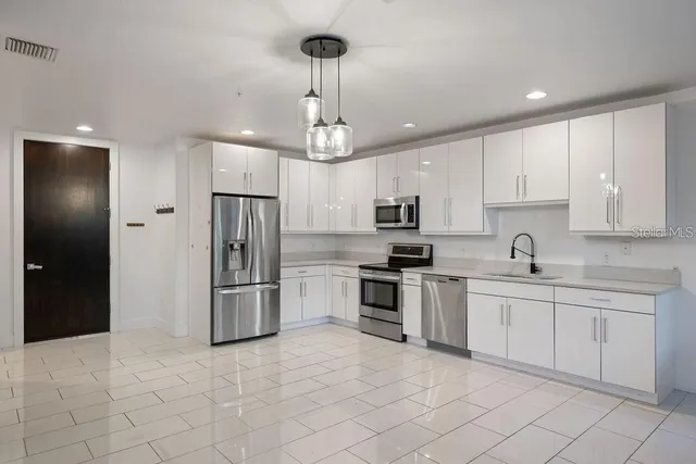 a kitchen with stainless steel appliances granite countertop a refrigerator and a sink