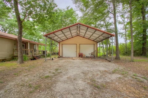 a view of a house with a yard and large tree