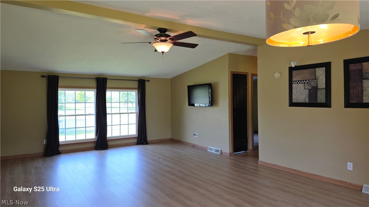 294 Twp 150 Road Sullivan, OH 44880 - Photo 20 of 39 Spacious interior featuring wood-finish flooring, a vaulted ceiling with exposed beam, and a ceiling fan with integrated lighting