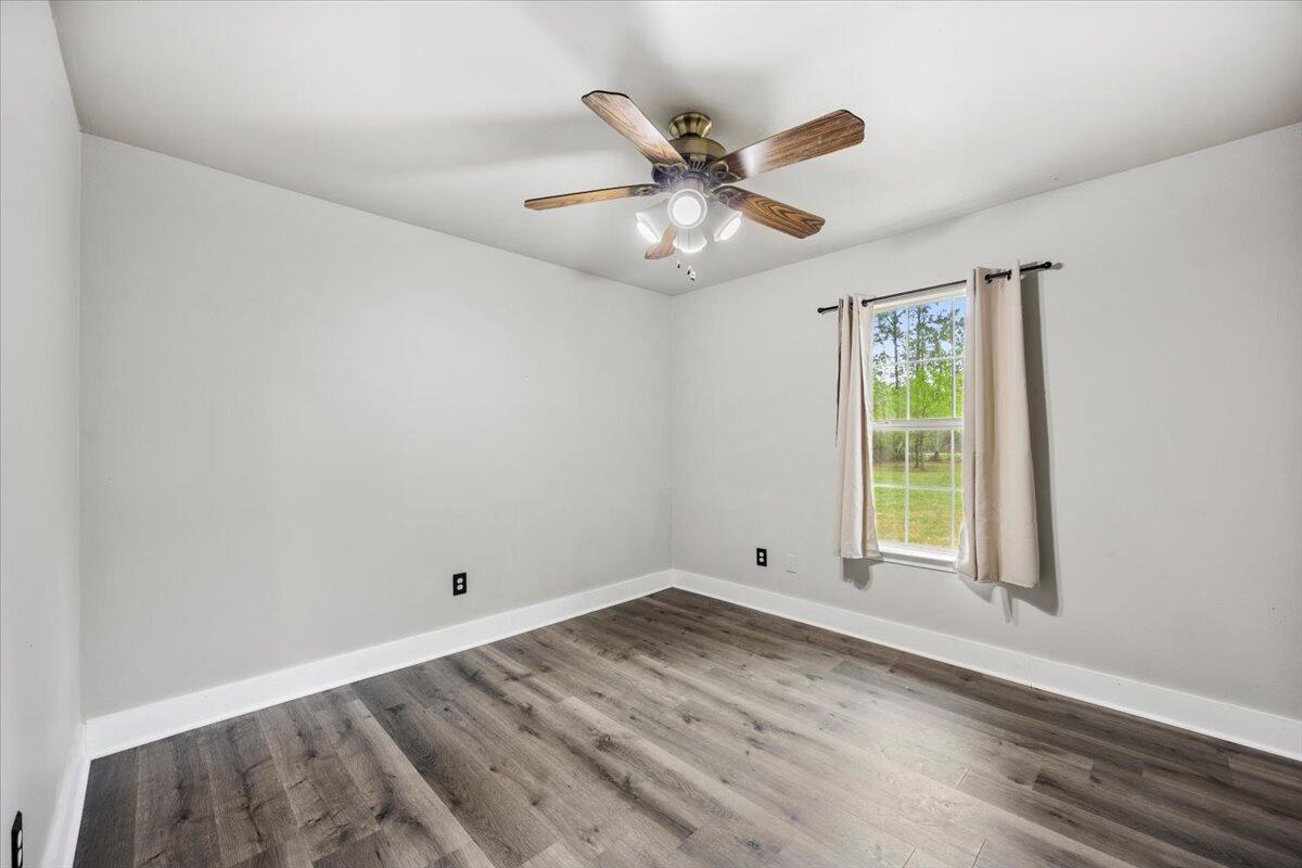 6060 Allegro Street Milton, FL 32583 - Photo 15 of 32 an empty room with wooden floor fan and windows