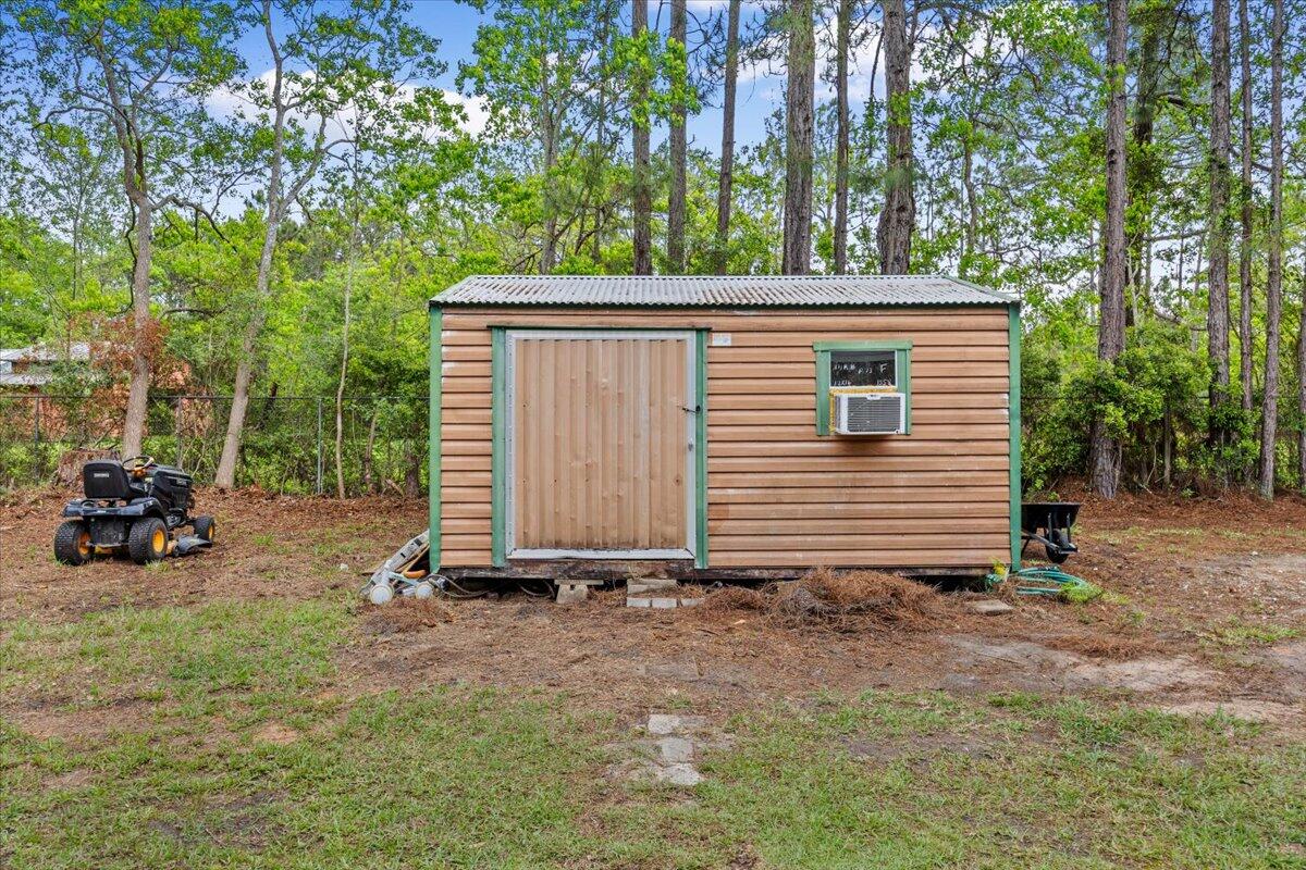 6060 Allegro Street Milton, FL 32583 - Photo 21 of 32 a view of a small house and a yard
