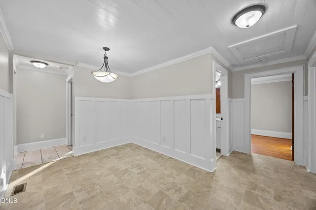 a view of an empty room with wooden floor and window