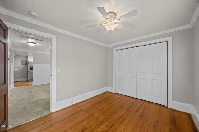 a view of a storage & utility room with closet and mirror