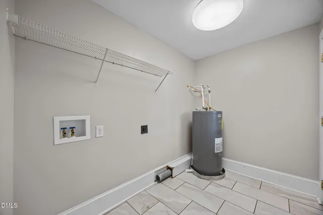 a view of an empty room with chandelier fan and windows