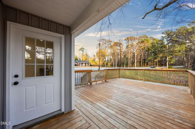 a view of a patio with couches chairs and wooden floor