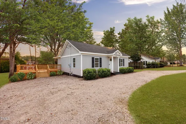 a front view of a house with a yard covered in snow