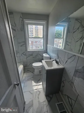 an empty room with wooden floor chandelier fan and windows