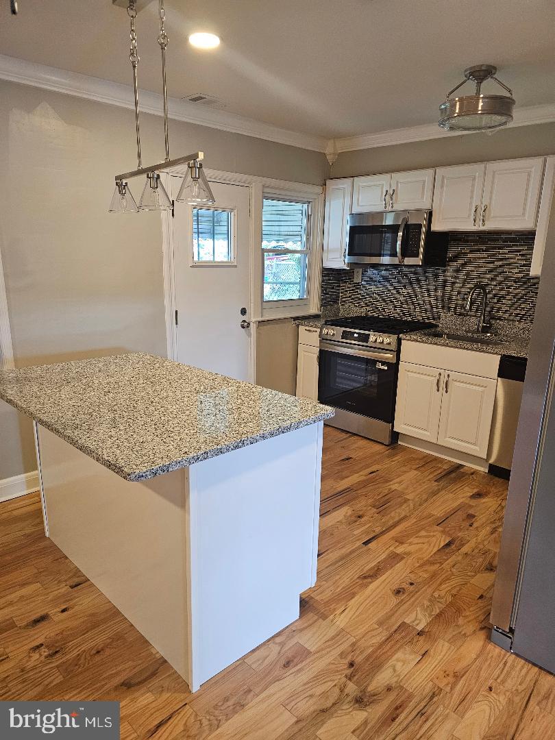 506 Allendale Street Baltimore, MD 21229 - Photo 6 of 27 a kitchen with kitchen island granite countertop wooden cabinets and a stove